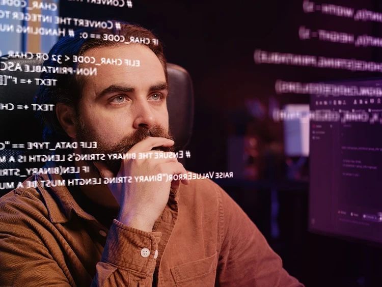 Sviluppatore guarda attentamente una lavagna virtuale con stringhe di codice.