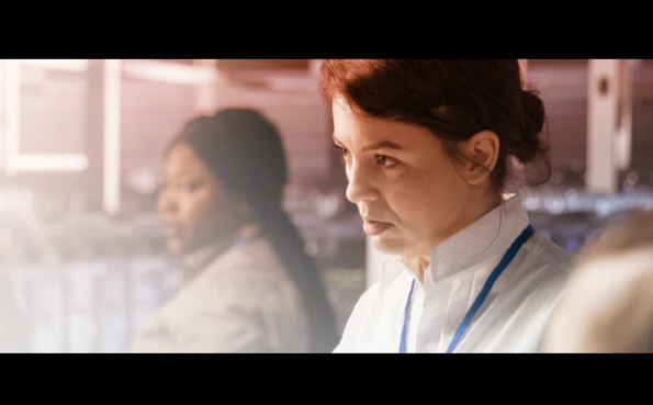 Professional in a high-tech environment using a tablet to manage cybersecurity protocols and monitor data security.