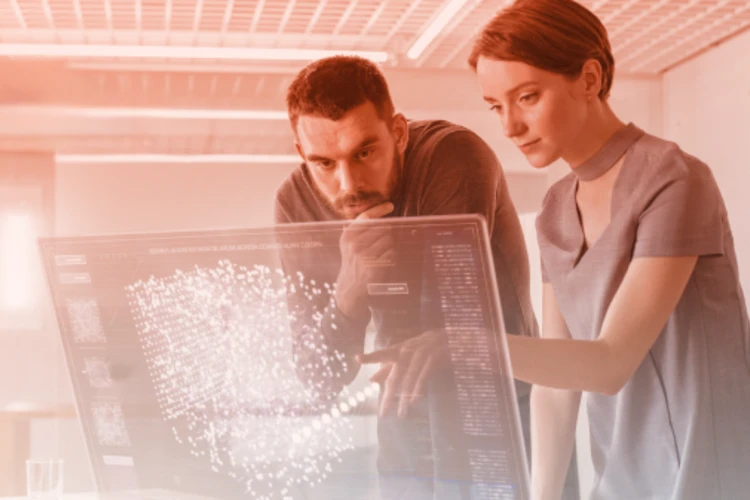 Two professionals analyse complex data on a transparent holographic screen in a modern environment.