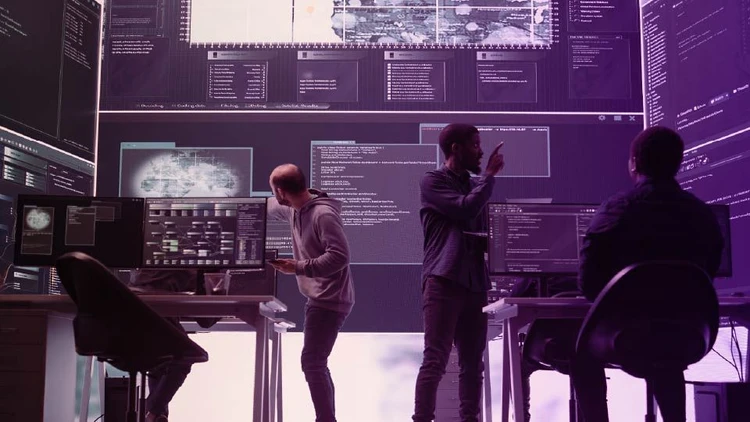 Team di professionisti IT impegnati nella supervisione e ottimizzazione di sistemi cloud & infrastructure in una control room high-tech.