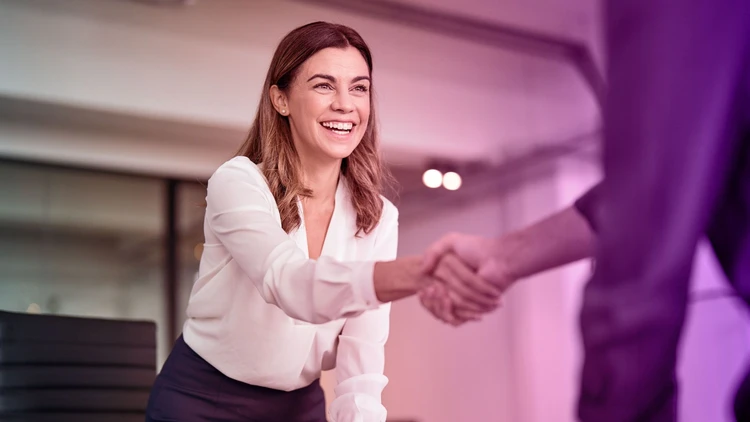 Handshake between a smiling woman and a male profile