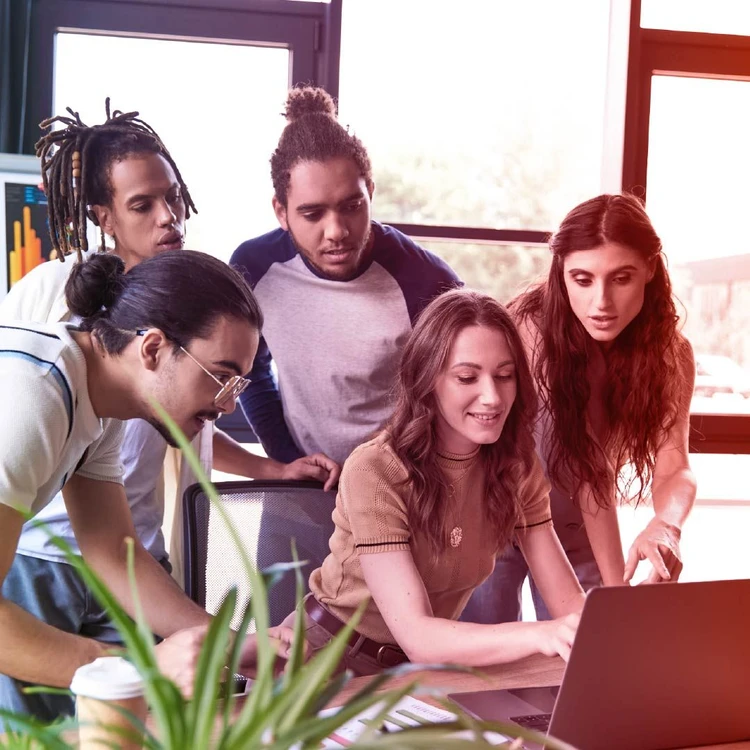 Giovani professionisti collaborano su un computer portatile durante un workshop del Master in Digital Transformation