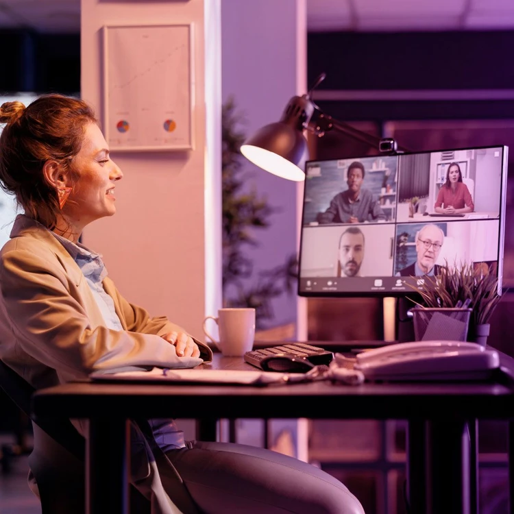 Gruppo di colleghi che lavorano in modalità ibrida, collegandosi in videochiamata su pc.